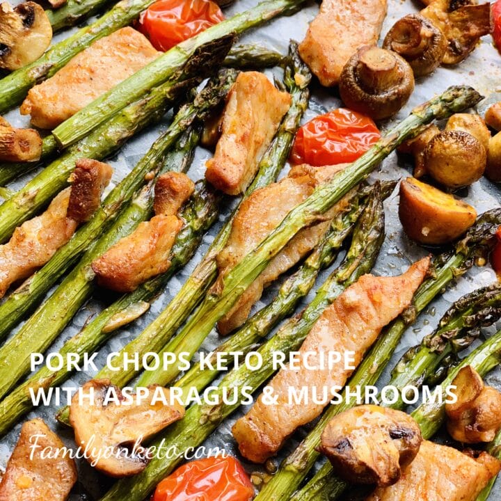 Picture of pork chops in a baking tray baked with asparagus, mushrooms and cherry tomatoes