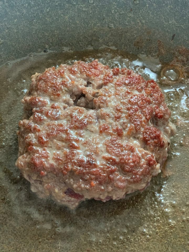Picture of cooking a burger patty on a frying pan