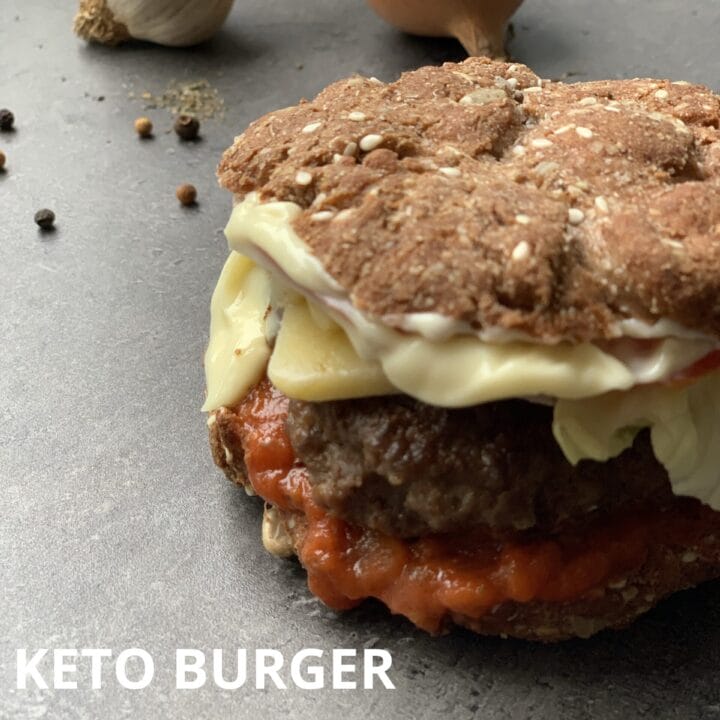 Picture of a keto burger in a keto bun with mayonnaise and keto tomato sauce