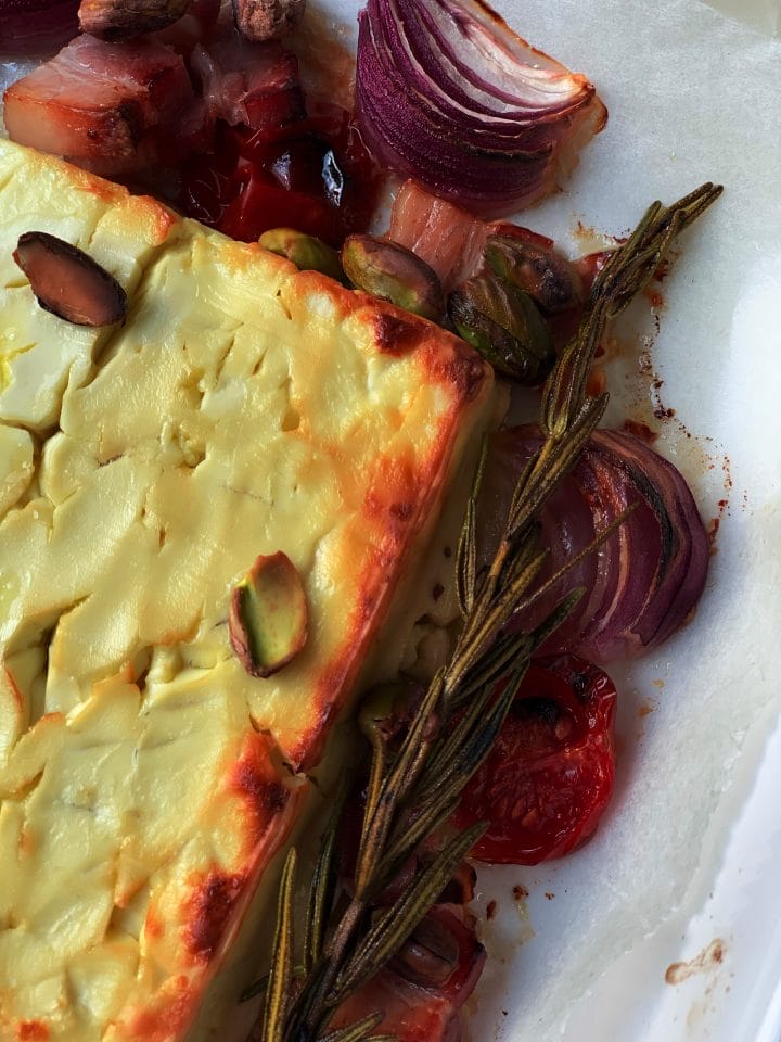 Picture of baked feta cheese with bacon, rosemary and cherry tomatoes