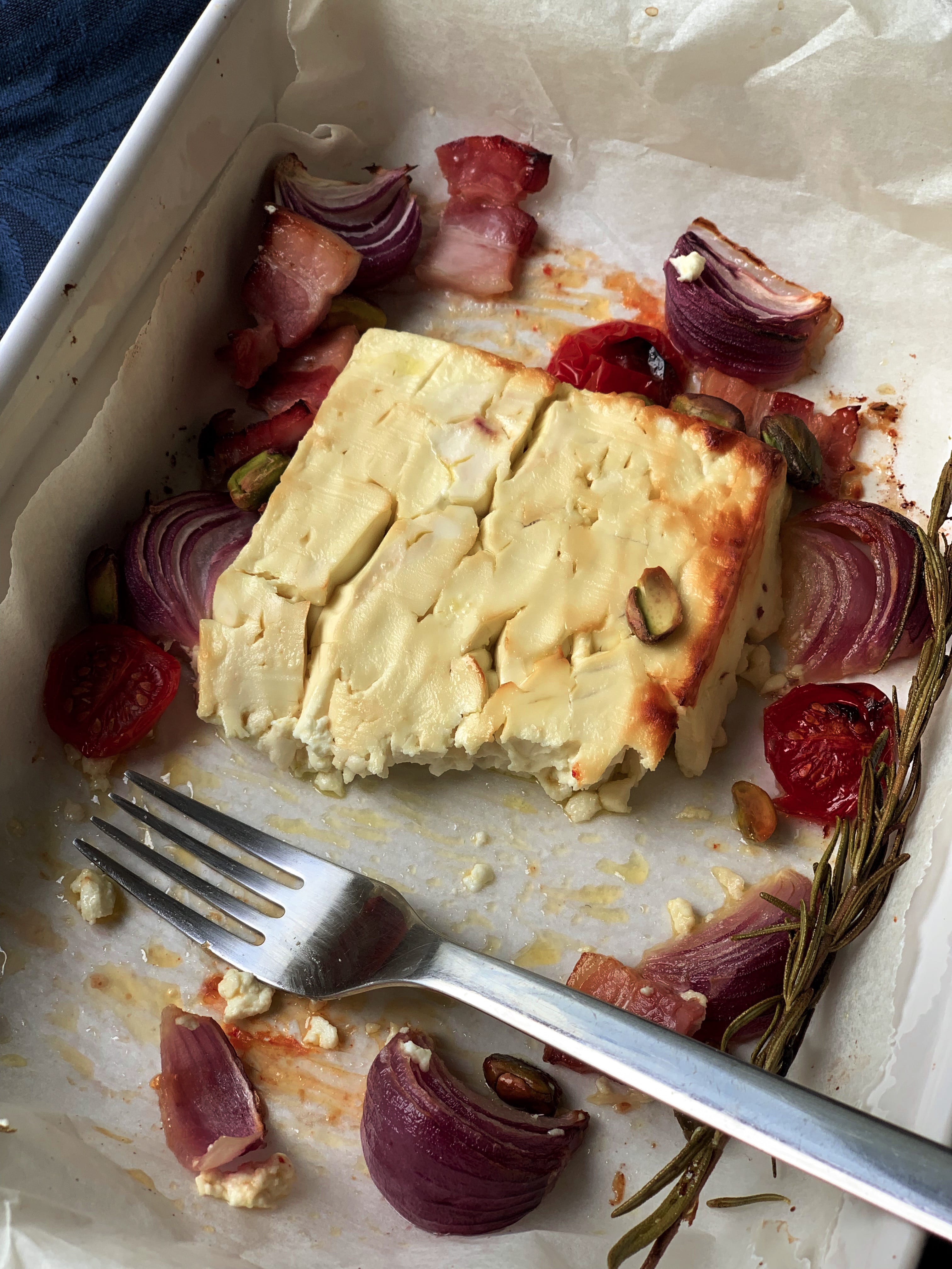 Picture of baked feta cheese with onion, bacon and pistachios