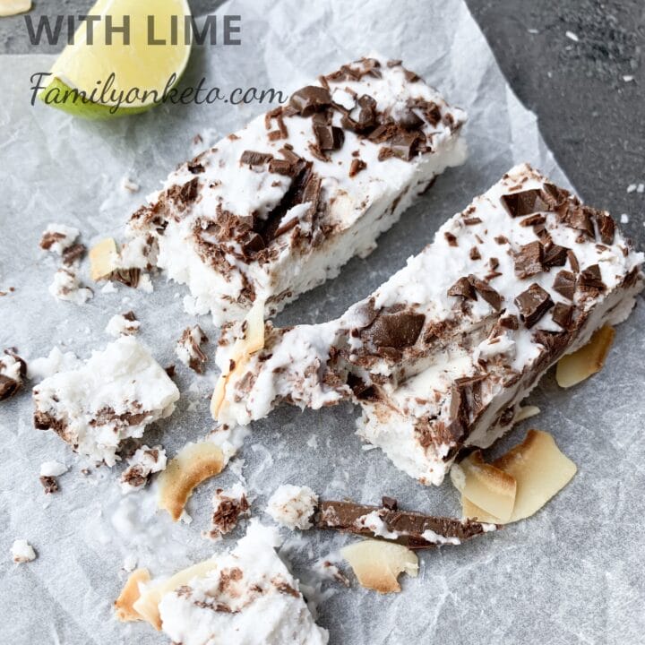 Picture of keto coconut ice cream cake bars on the table wit lime slices