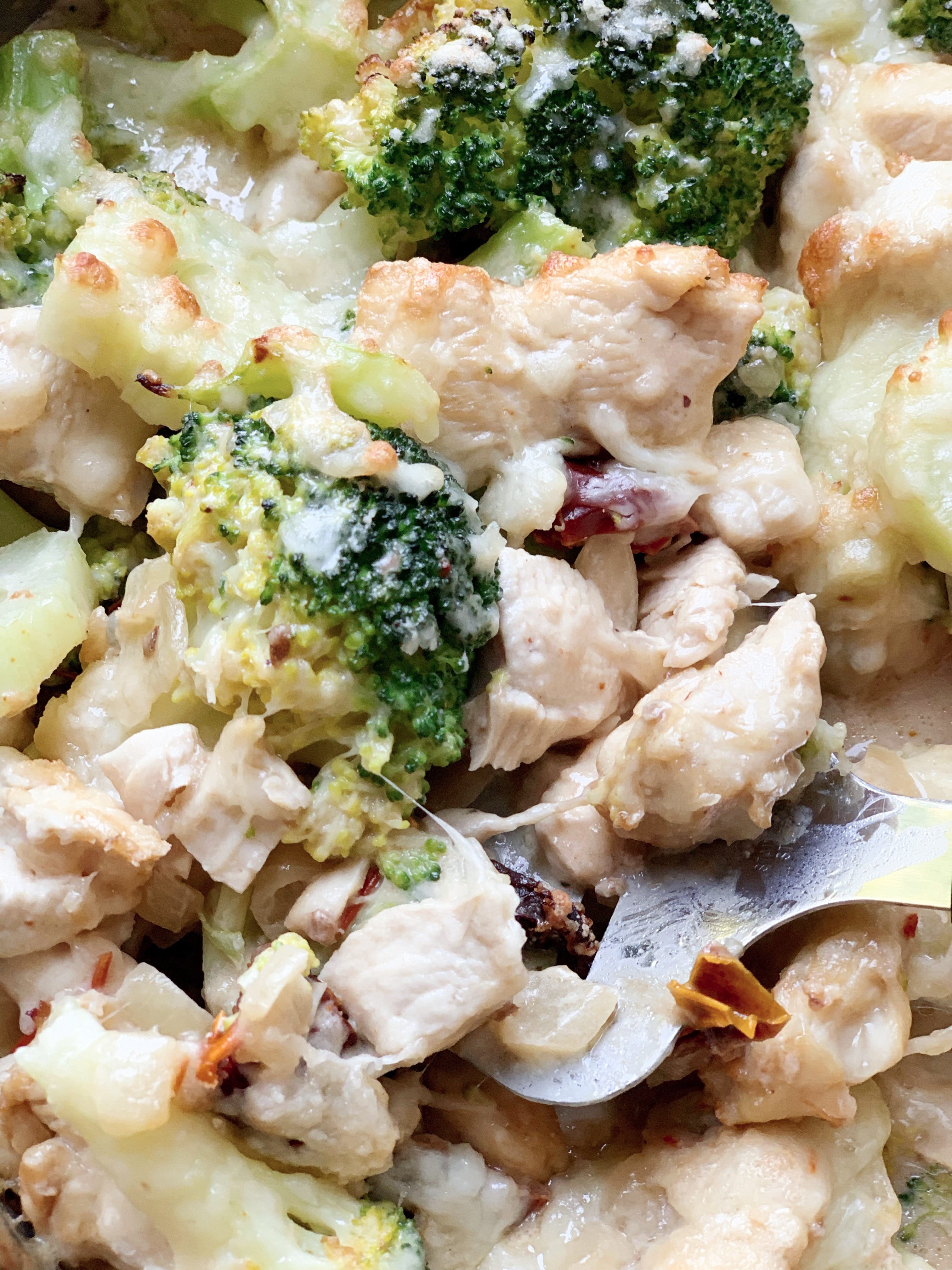 Picture of keto broccoli and chicken casserole with sun dried tomato sauce and mascarpone cheese in skillet