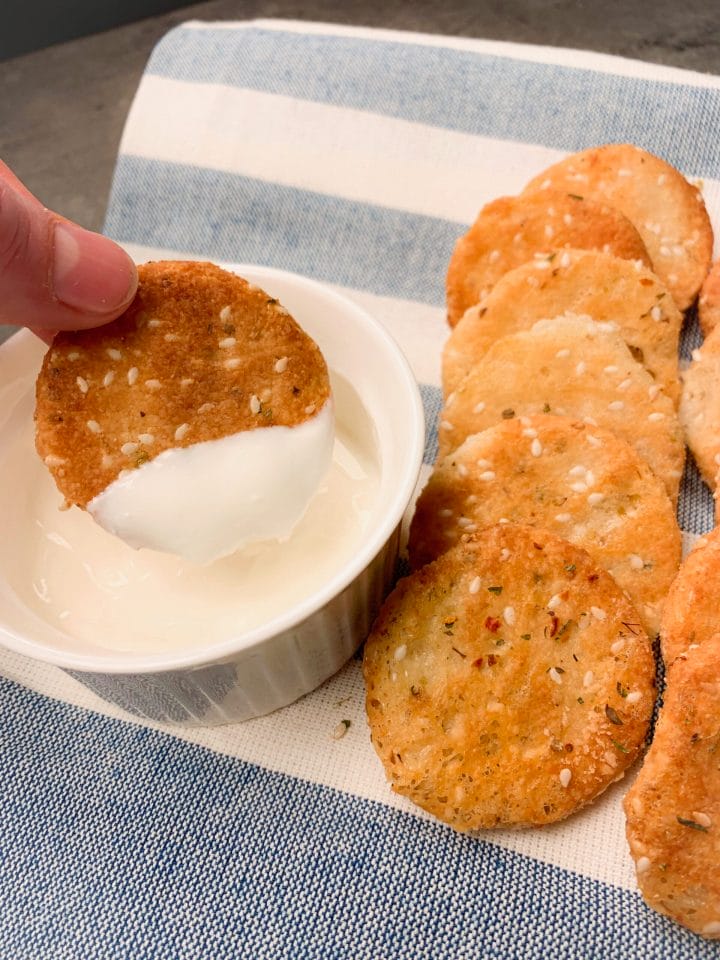 Picture of healthy cheese crackers dipped into a sour cream sauce