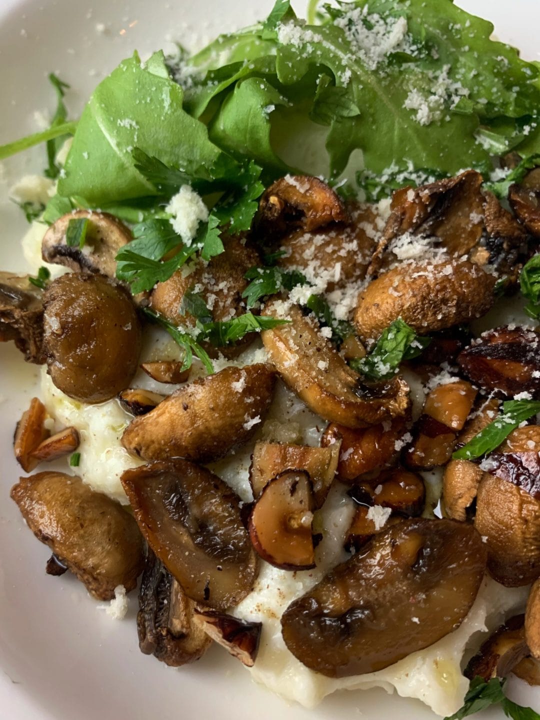 Picture of a keto bowl of roasted mushrooms with hazelnuts and arugula
