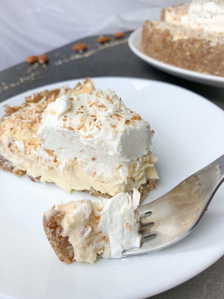 Keto coconut cream pie slice on a plate and piece on a fork