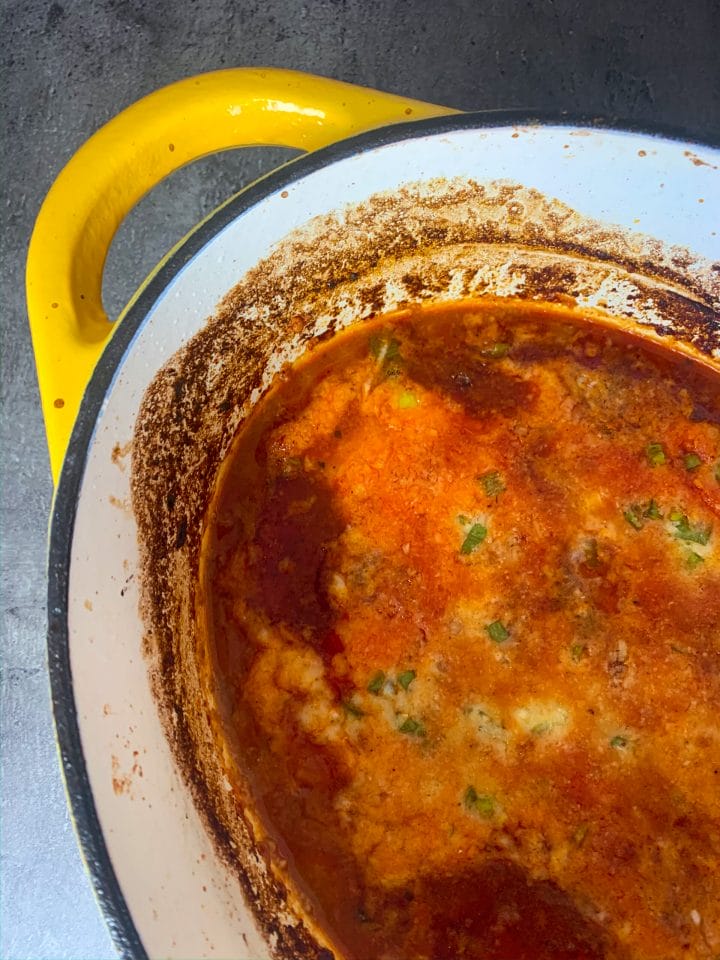Picture of a Dutch oven with keto chili with a cheese crust on top