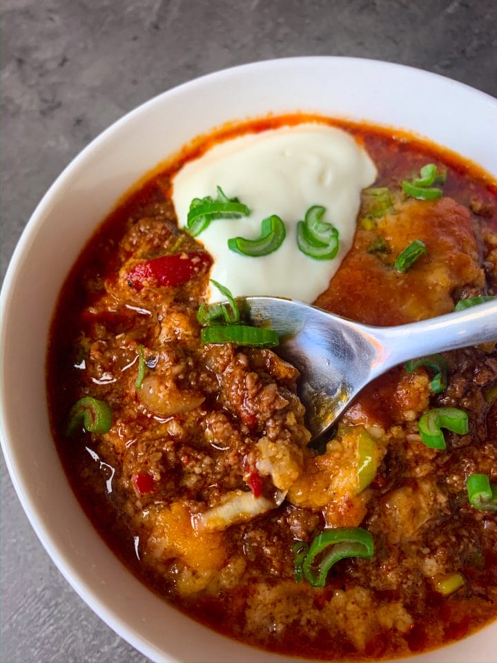 Picture of a bowl full of keto chili with a spoon in