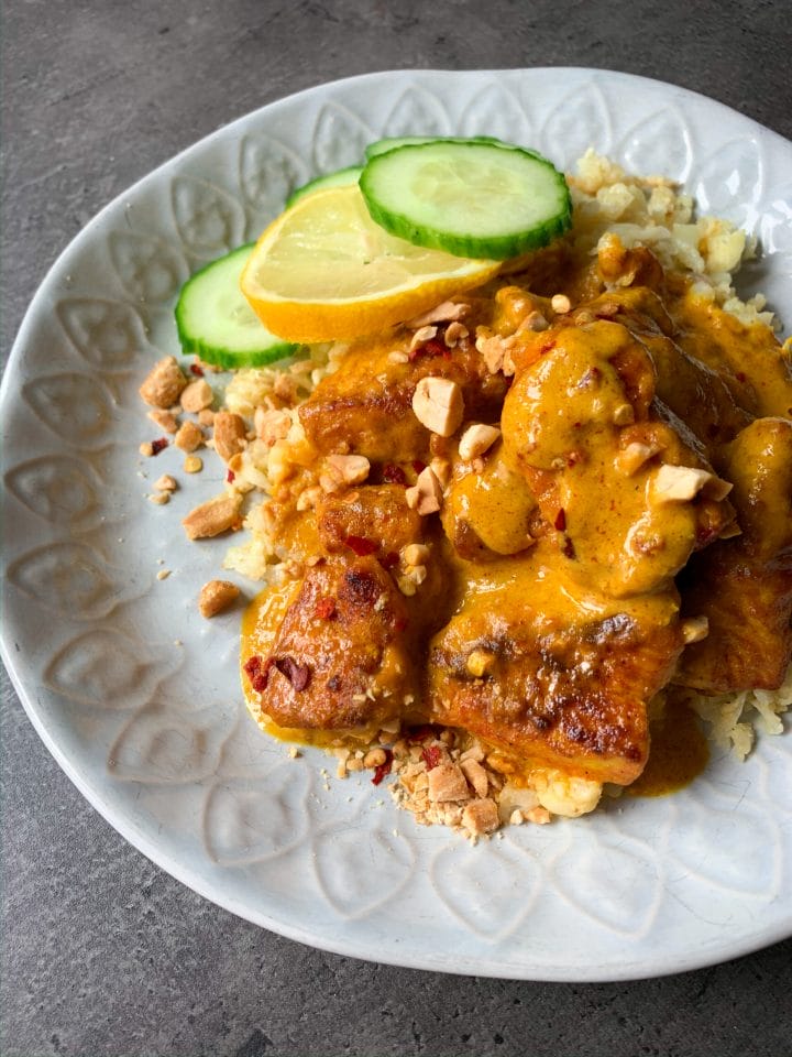 Picture of chicken with peanut sauce recipe in a plate with riced cauliflower