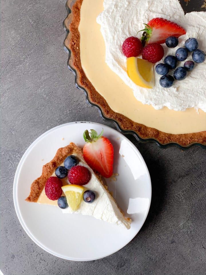 Picture of delicious keto lemon cream pie with heavy cream topping and berries