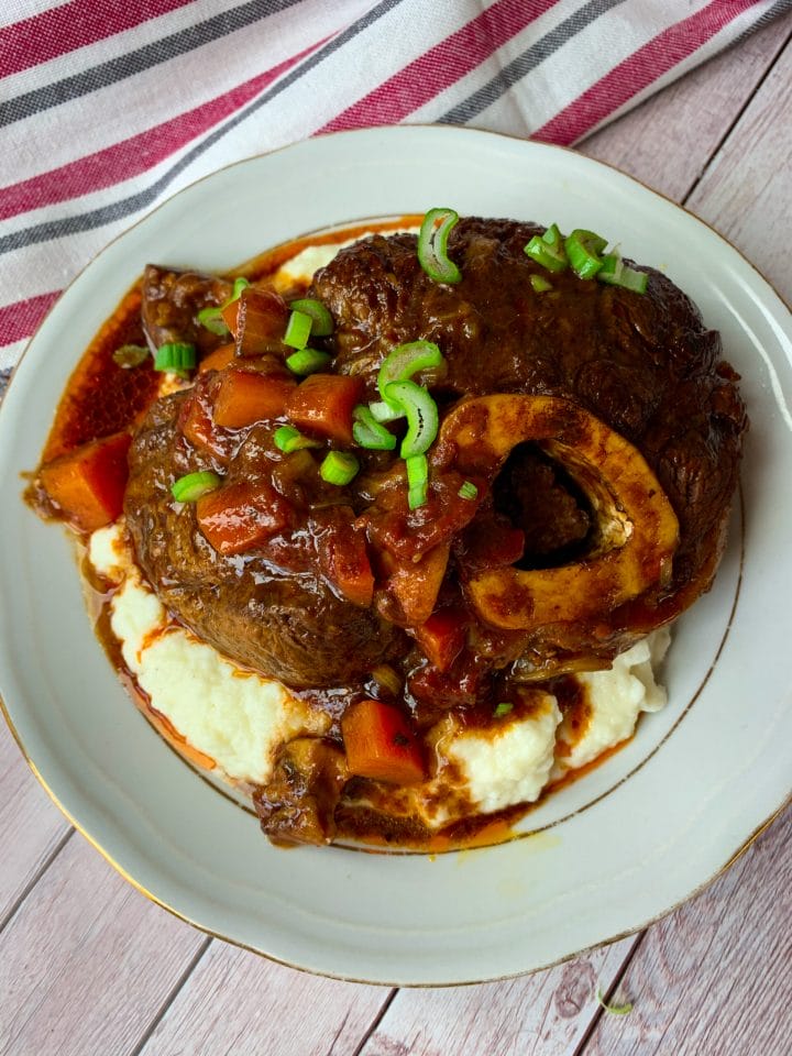 Beef ossobuco or keto osso buco with vegetable stew on a plate with cauliflower mash
