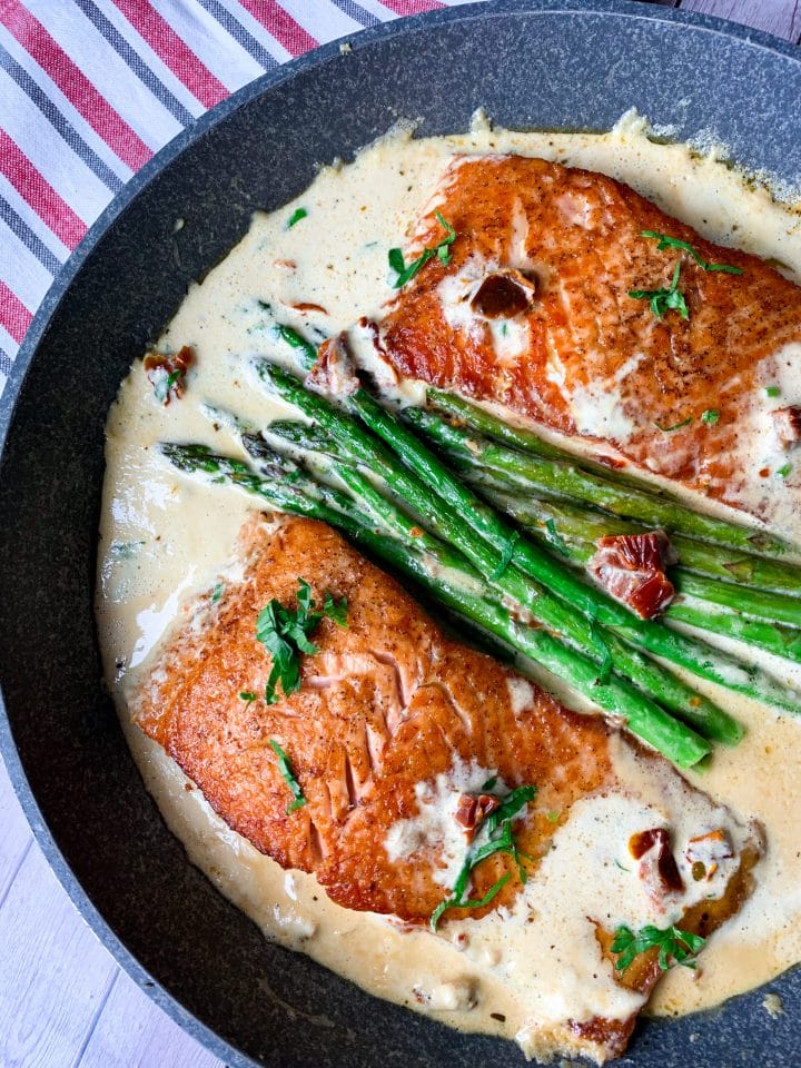 Picture of keto salmon recipe with asparagus in creamy Italian sauce with dried tomato and garlic