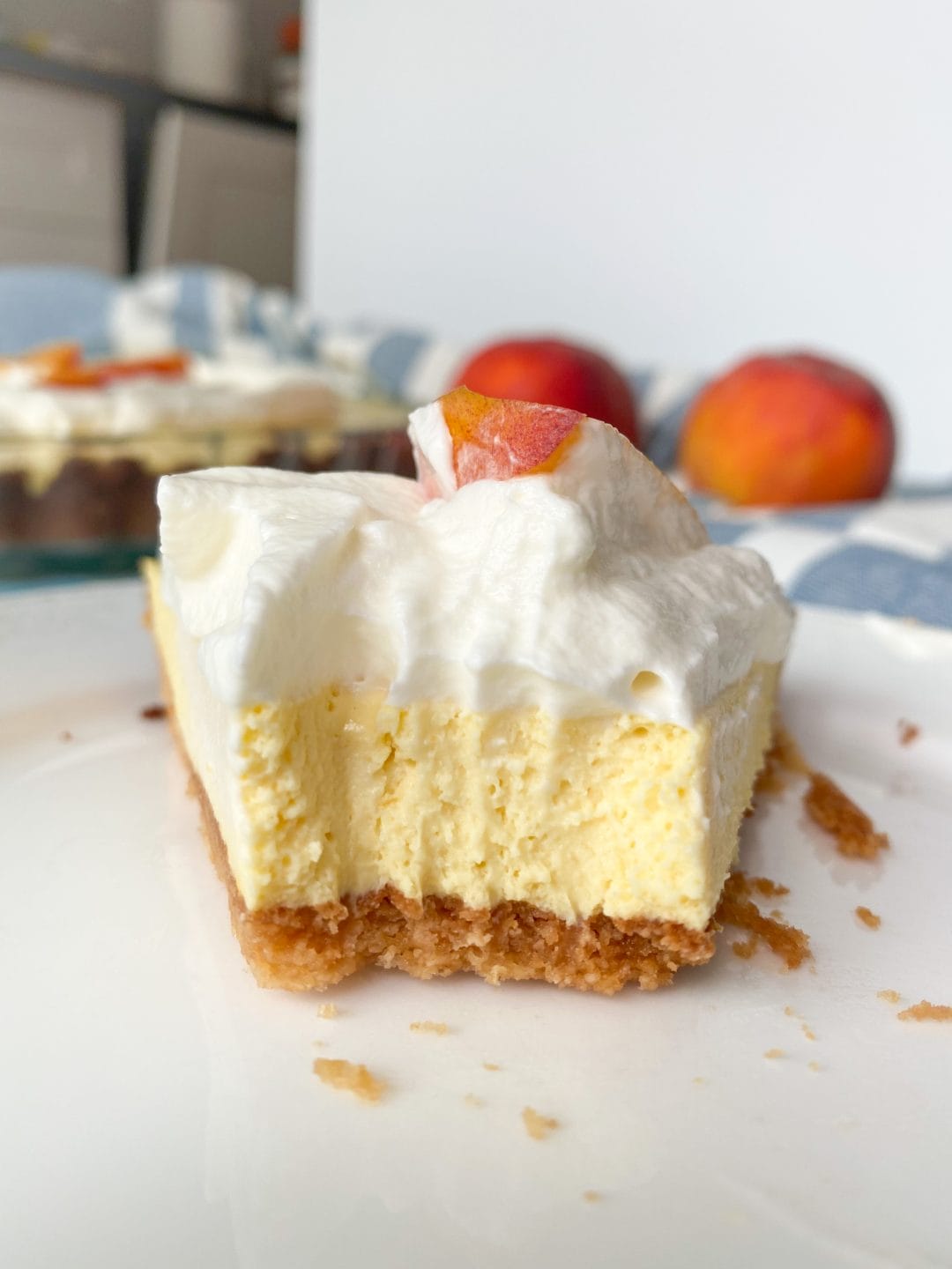Picture of a slice of low carb peach cream pie with cream and peach slice on top