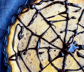 Picture of keto Halloween pumpkin pie with spider web on top