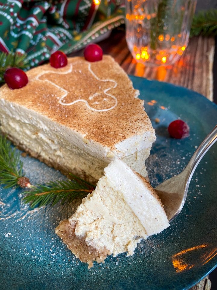 Picture of keto gingerbread cheesecake slice and one piece on a fork with Christmas decoration in the background