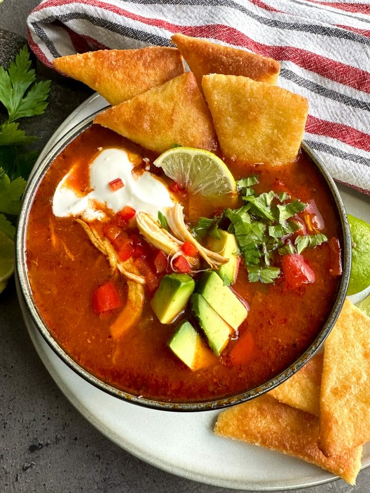 Bowl of keto chicken tortilla soup with low carb tortilla chips
