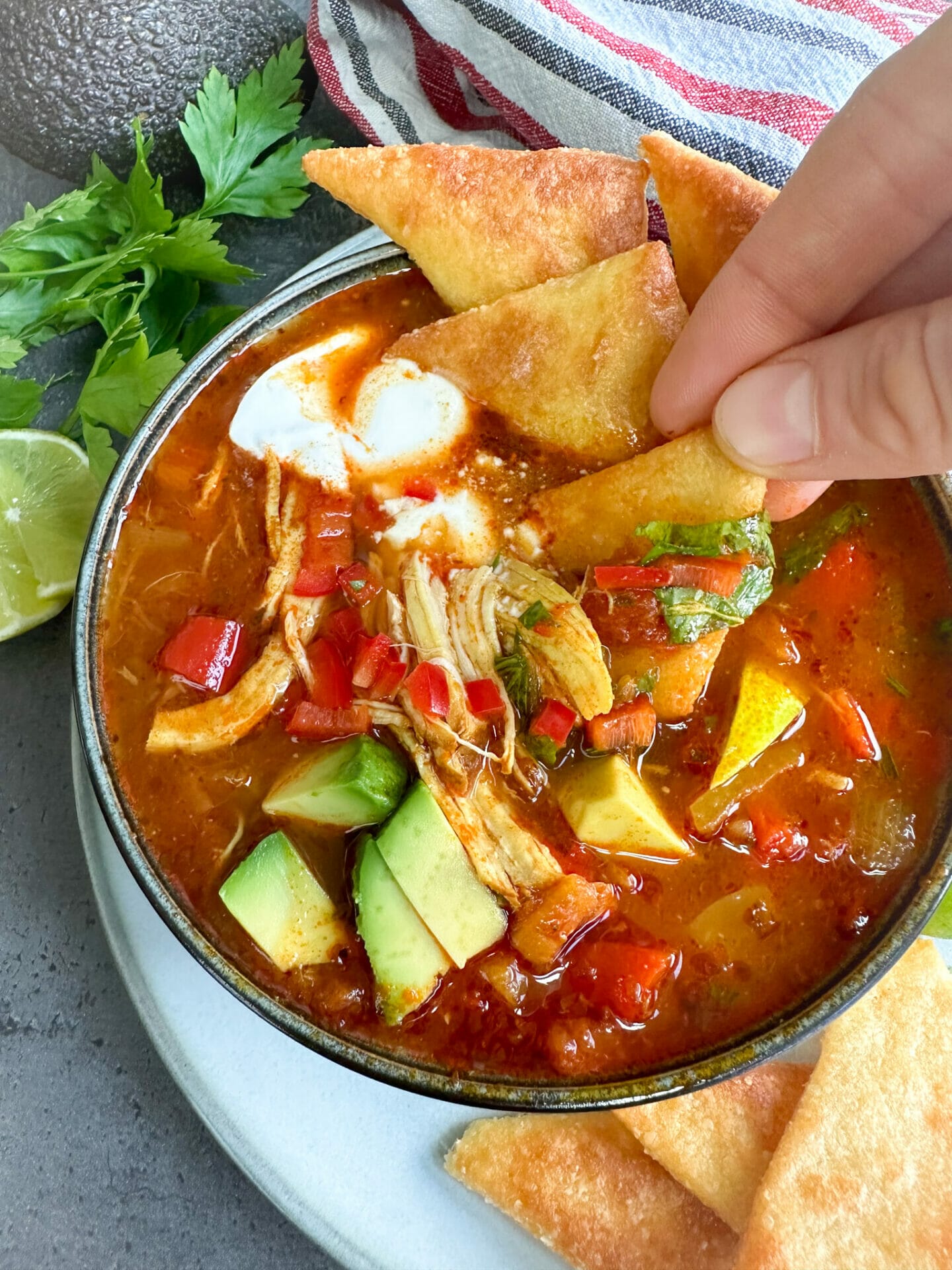 Picture of dipping low carb tortilla chips into keto Mexican soup chicken